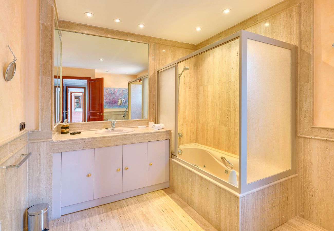 Spacious wooden bathroom with glass shower screen