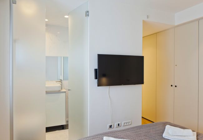 Modern bedroom with a tv in apartment on Ben Yehuda st.