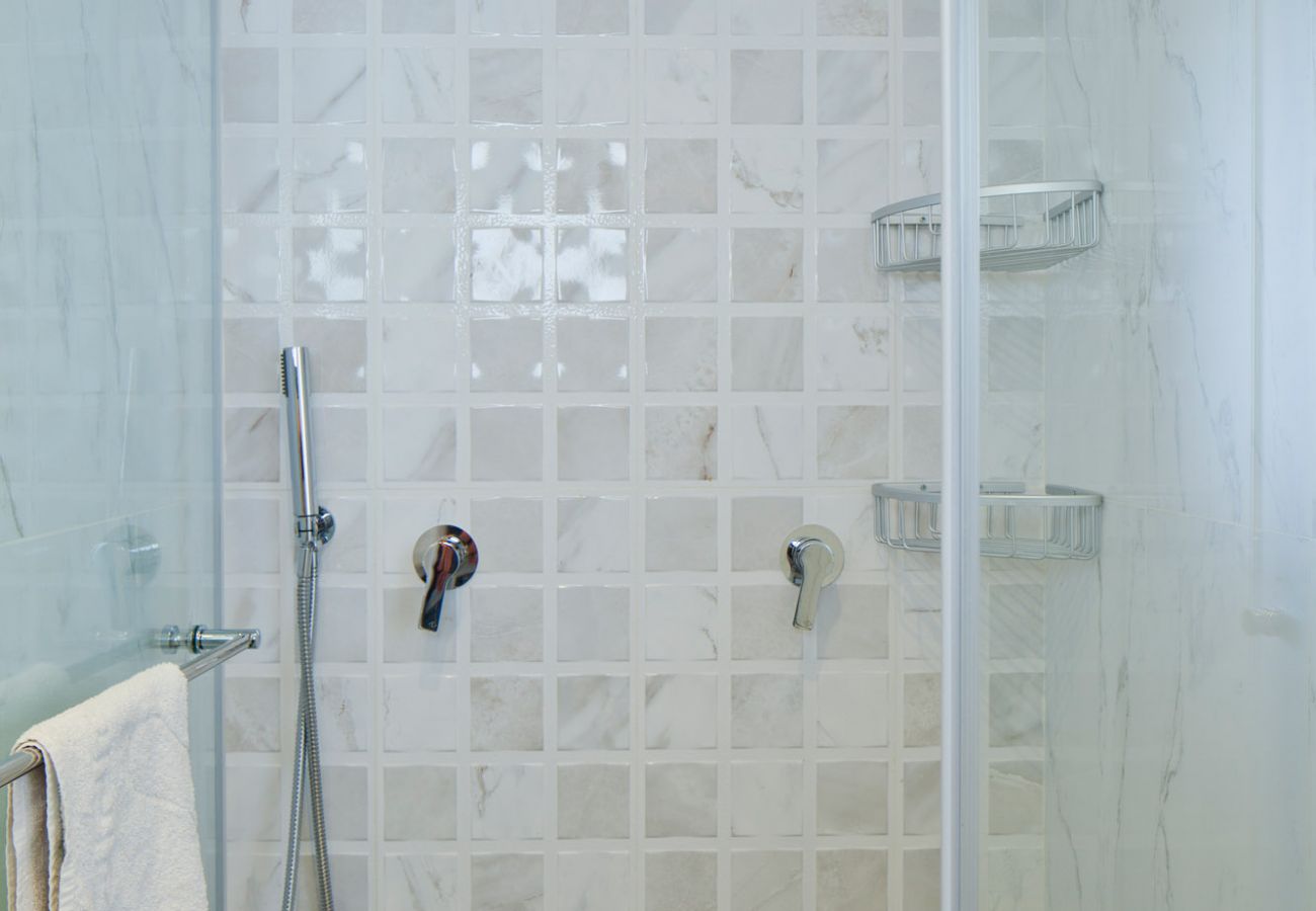Modern shower with a towel in apartment on Ben Yehuda st.
