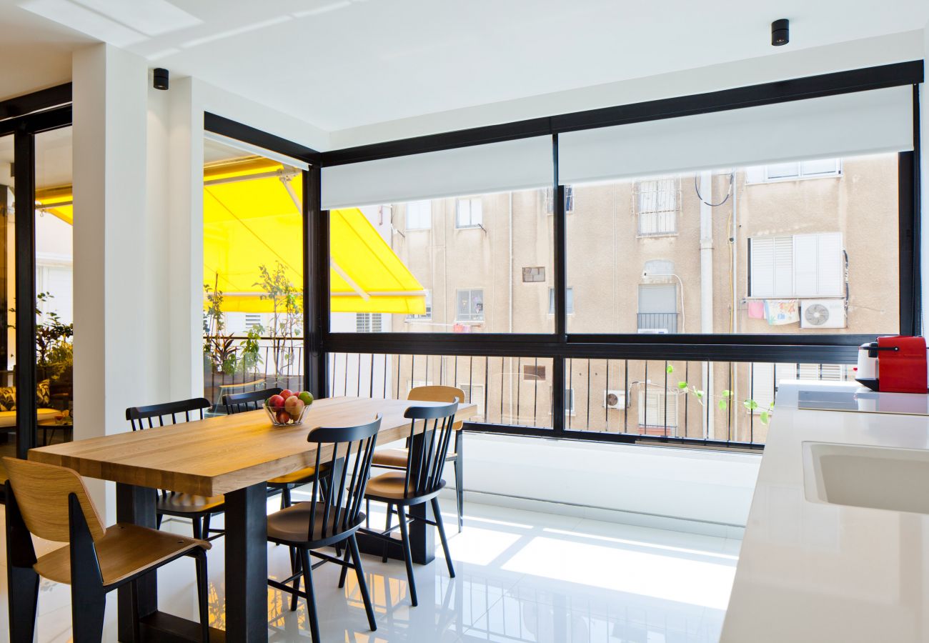 Luminous dining area with a giant window in apartment on Ben Yehuda st.