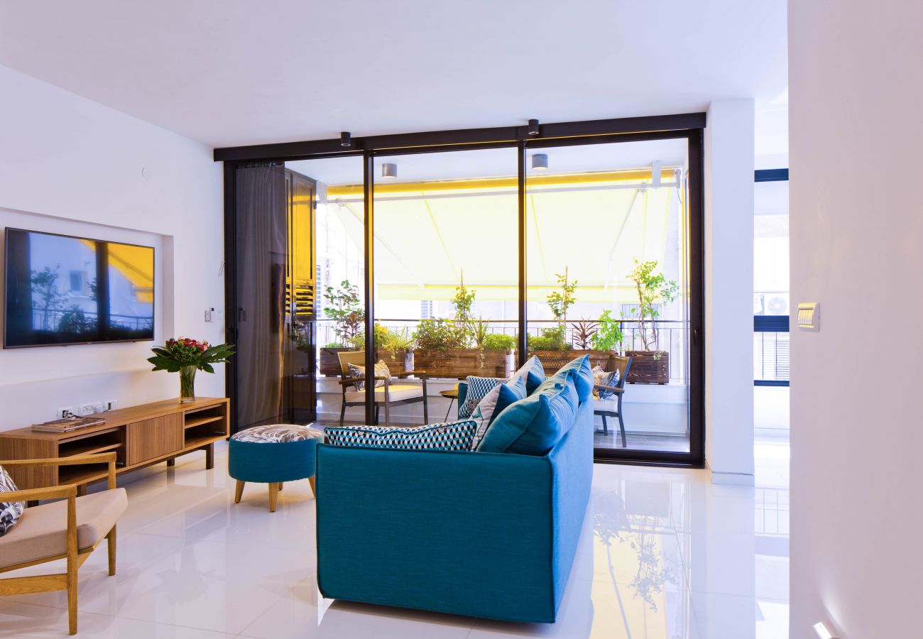 Sunny living room with a comfy couch, tv and a gorgeous terrace in apartment on Ben Yehuda st.