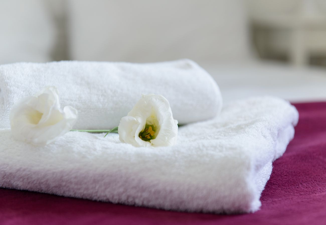 Clean towels with flowers on the bed in apartment on Ben Yehuda st. 