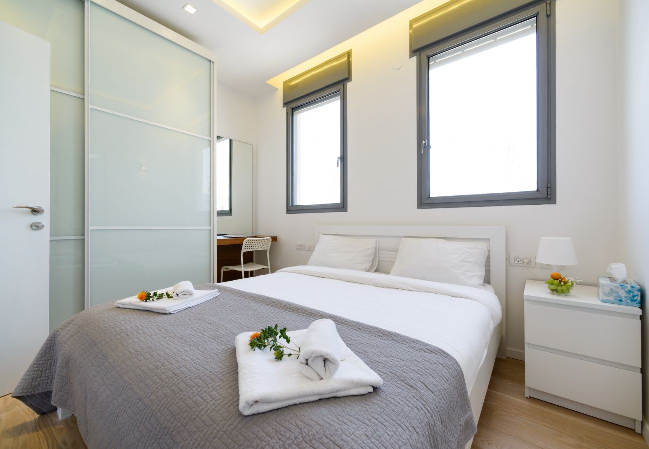 Bright bedroom with a big comfy bed and work area on Ben Yehuda st.