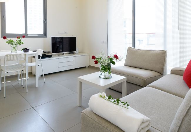 Modern living room with big couch and a tv on Ben Yehuda st.