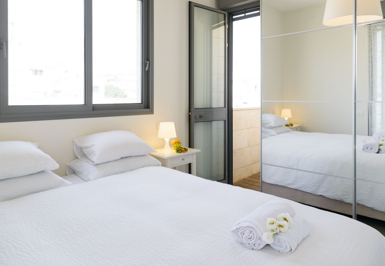 Bright bedroom with big comfy bed and closet with mirror doors on Ben Yehuda st.