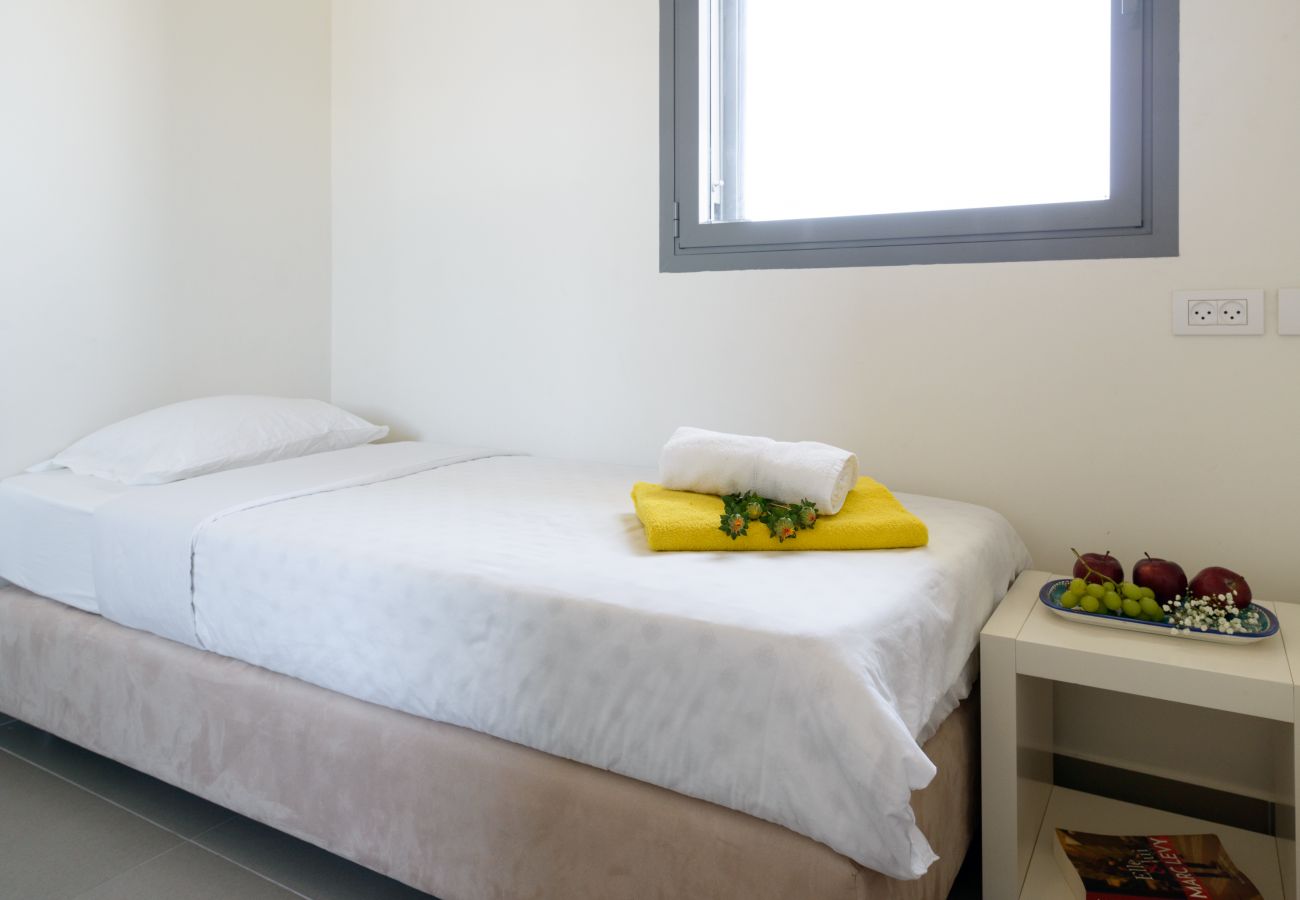 Bright bedroom with a comfy bed in apartment on Ben Yehuda st.