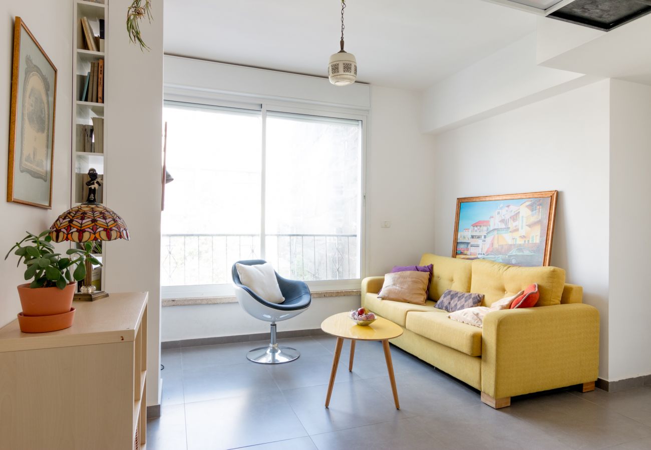 Colorful living room with yellow sofa and modern interior items in apartment in Florentine 